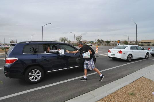 Rob passes out newspapers to the cars